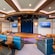 An auditorium at the Triton Lounge with a stage, upholstered seating and small tables
